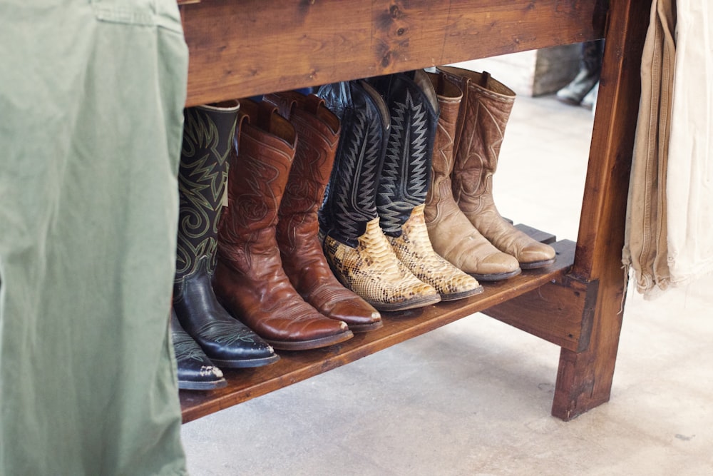 a wooden bench with several pairs of cowboy boots on it