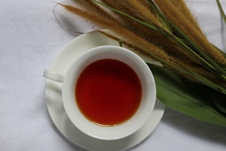 a cup of tea next to a bunch of grass