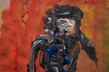 An abstract painting prominently featuring a blend of dark, bold strokes and lighter patches against a vibrant, textured background of red, orange, and yellow hues. The strokes seem to form a rough representation of a human figure.