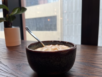 Traditional clay pots filled with creamy, homemade yogurt set on a wooden table.