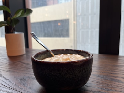 A happy customer enjoying a creamy yogurt in a bright kitchen setting.