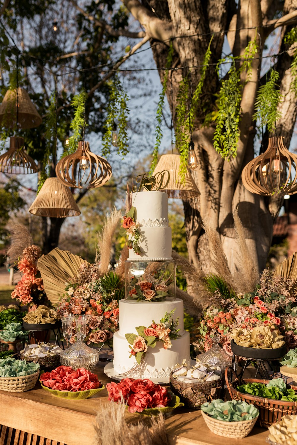 a table topped with a tall white cake covered in flowers