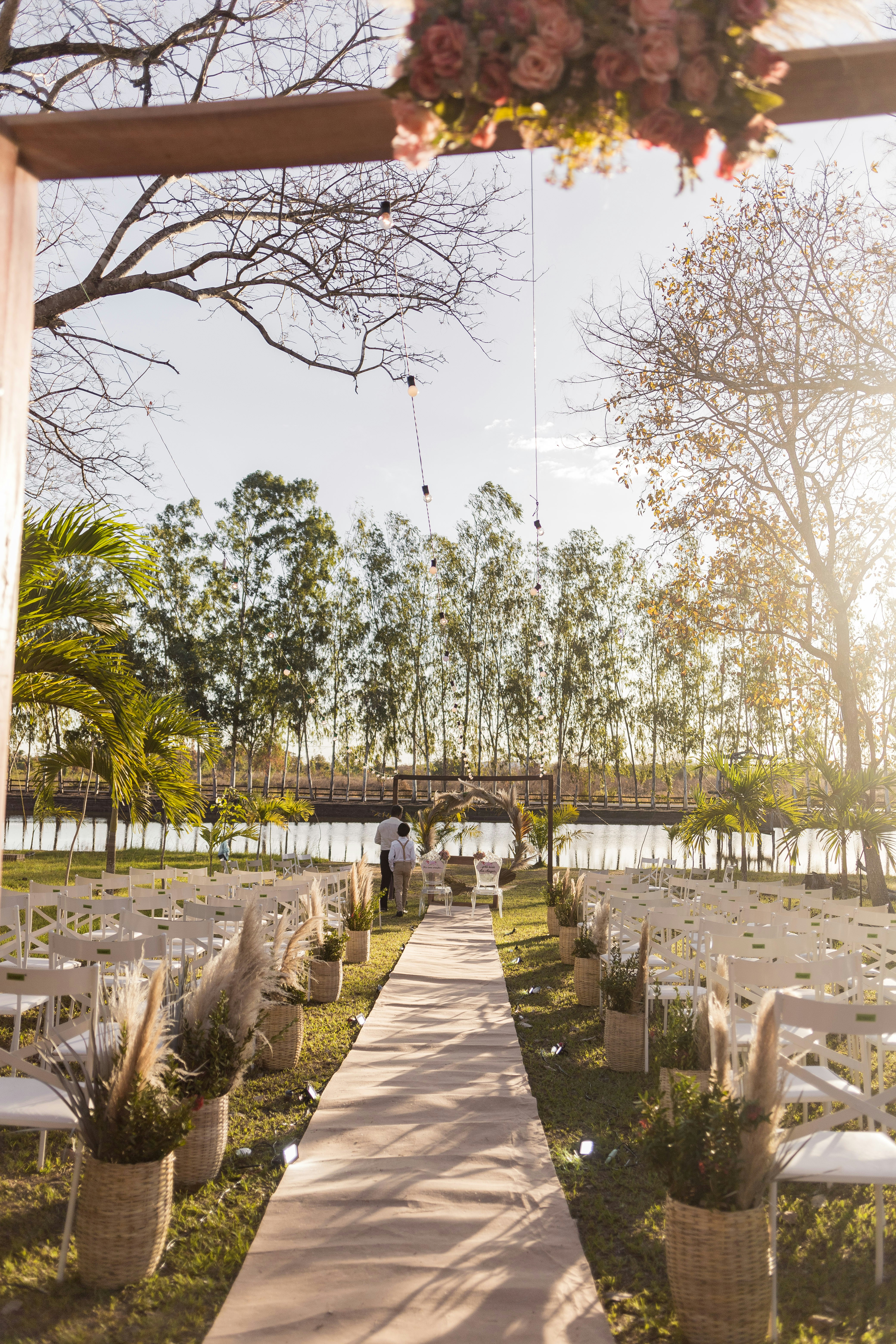 an outdoor ceremony setup with white chairs and flowers