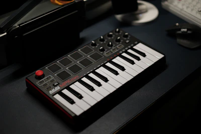 A sleek MIDI keyboard controller with colorful backlit keys glowing in a modern studio setting.