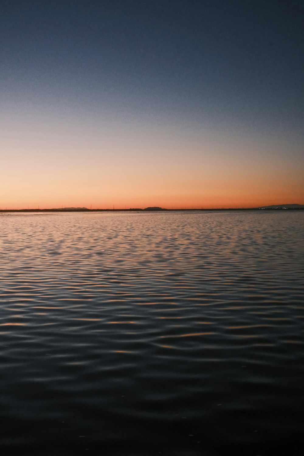 a large body of water with a sky in the background