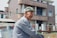A smiling customer, John D., standing in front of his new home.