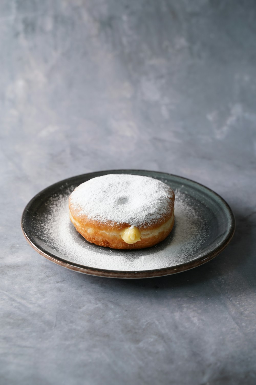 a powdered doughnut on a plate on a table