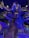 A large, intricately detailed artificial tree structure indoors, with wooden stairs winding up to multiple levels and platforms. Blue and purple lighting creates a magical atmosphere, highlighting the textures and details of the tree's bark. The sign 'Tinkertree' is visible, indicating the theme or attraction name. The area beneath the tree is open, allowing for exploration and play.