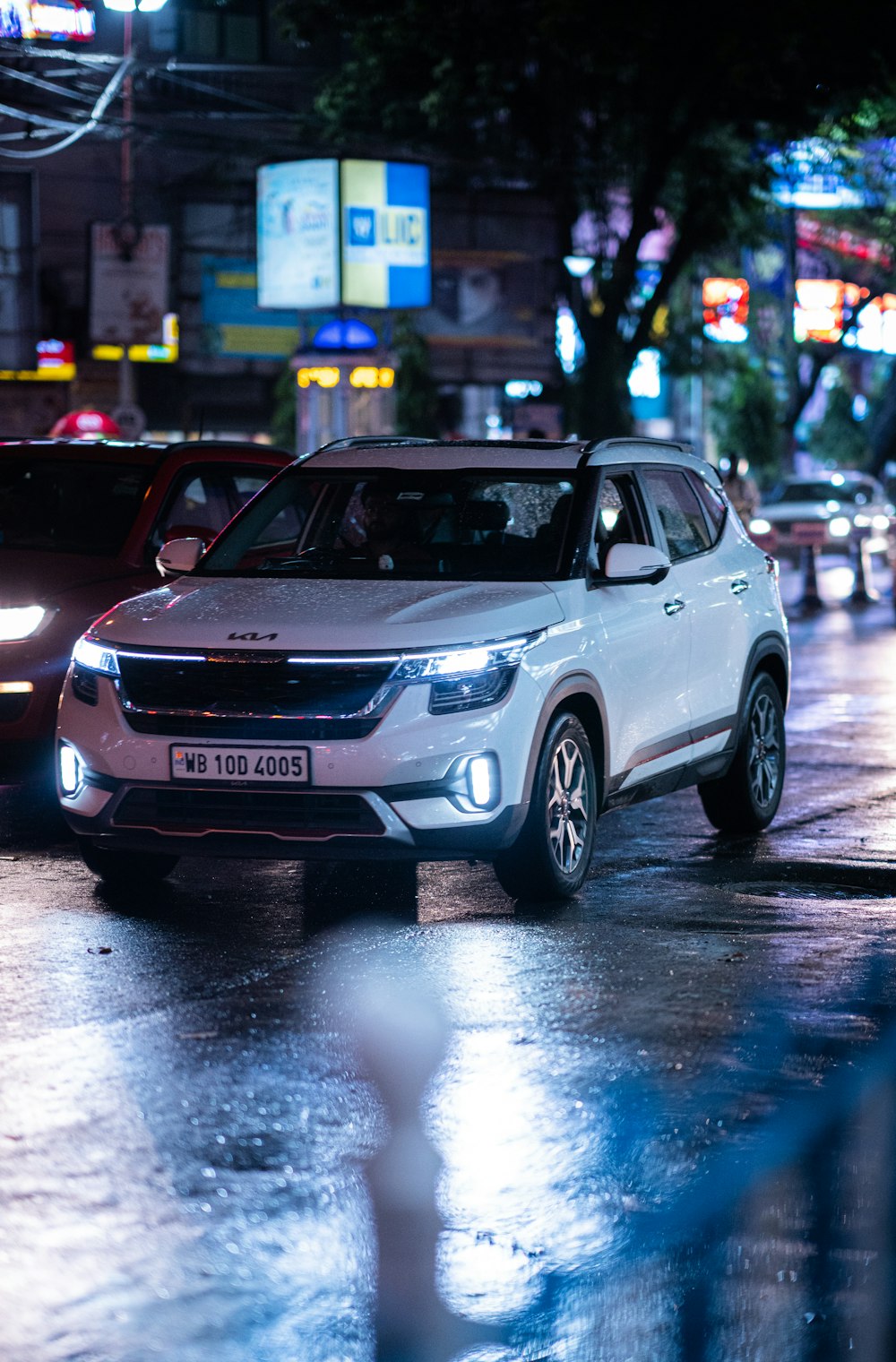 a white suv driving down a street at night