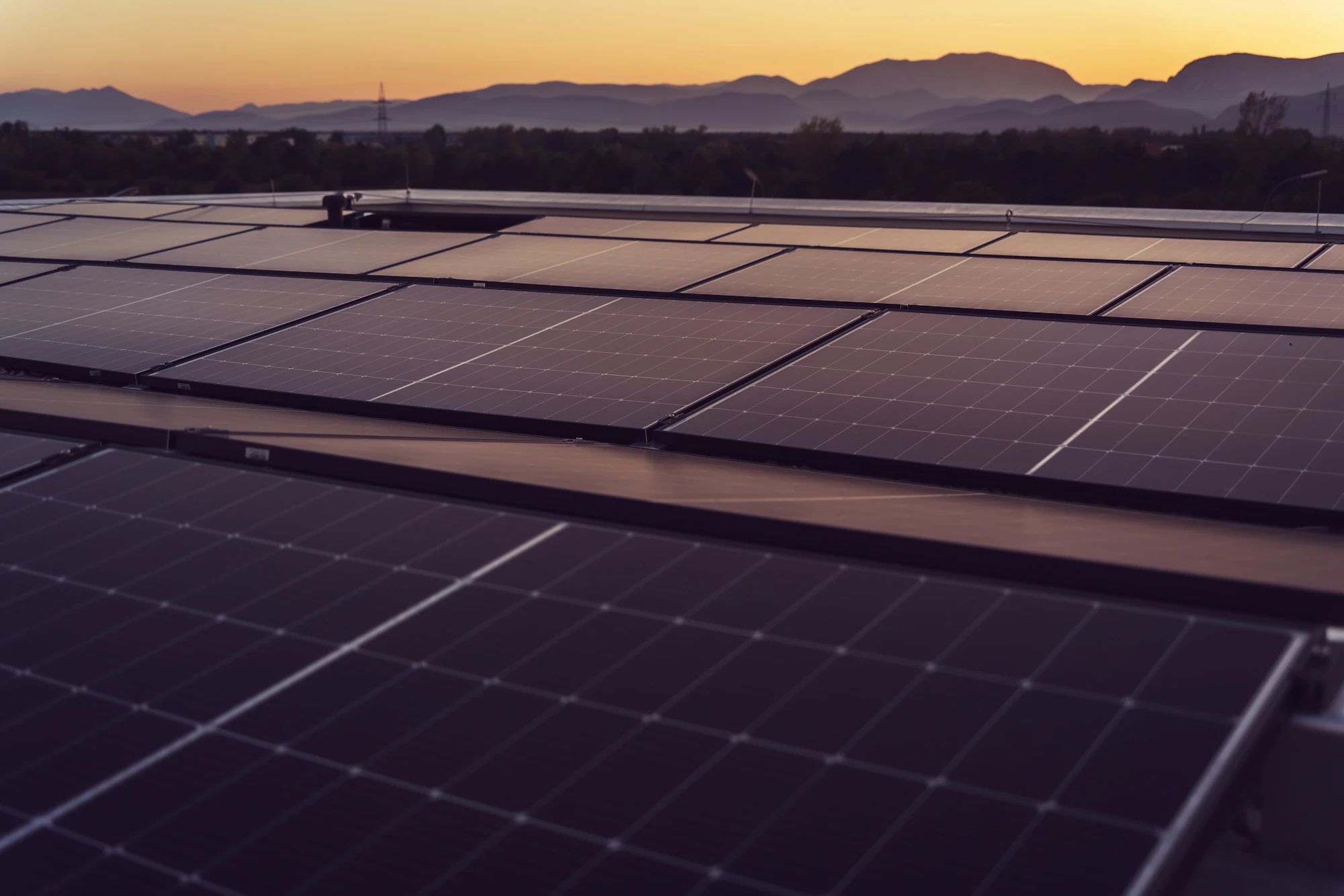 Planta solar sobre cubierta al atardecer con las sierras de Córdoba de fondo
