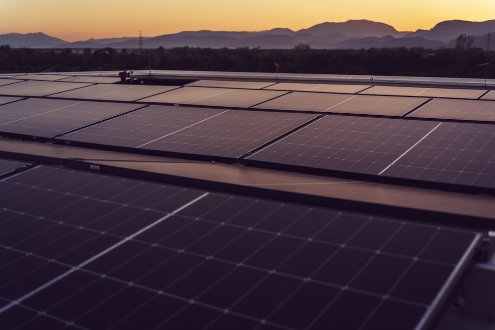 a large solar panel with mountains in the background