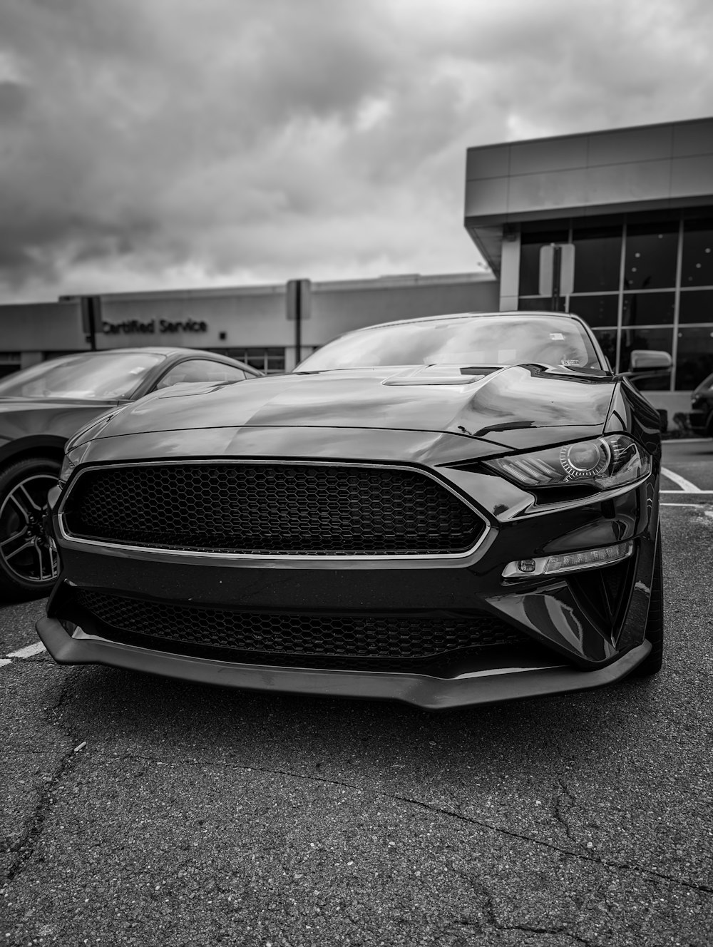 a black and white photo of a car in a parking lot
