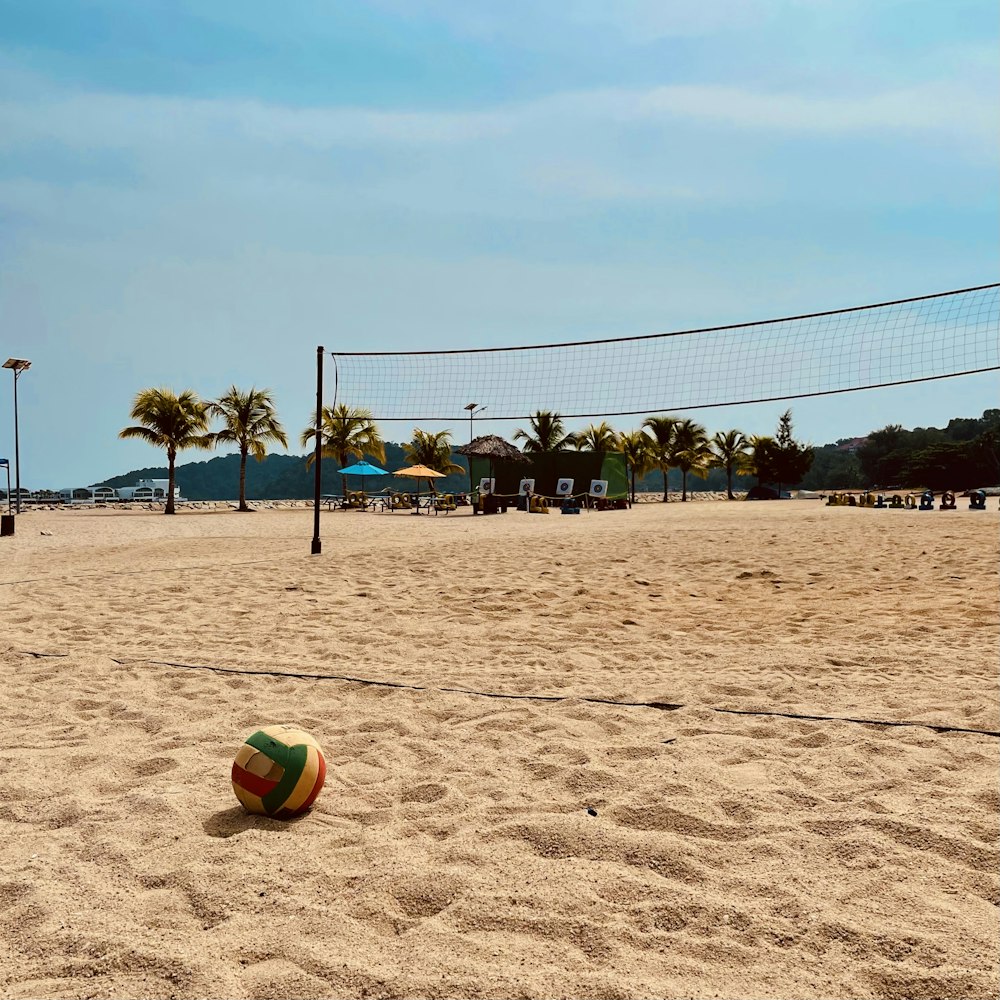 a beach volleyball ball sitting on top of a sandy beach