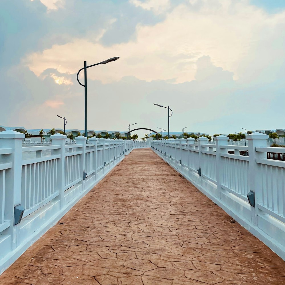 a long white bridge with a light pole and street lights