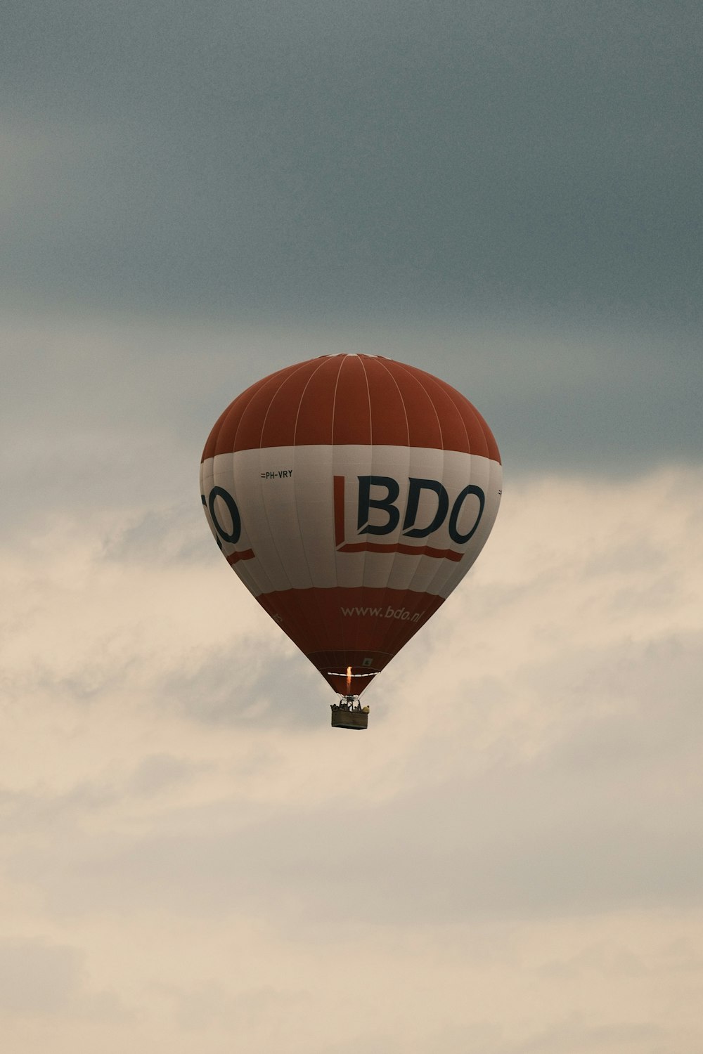 a red and white hot air balloon flying in the sky