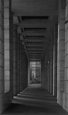 a black and white photo of a long hallway