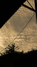 A surreal cloud-filled sky with subtle vintage typography overlay.