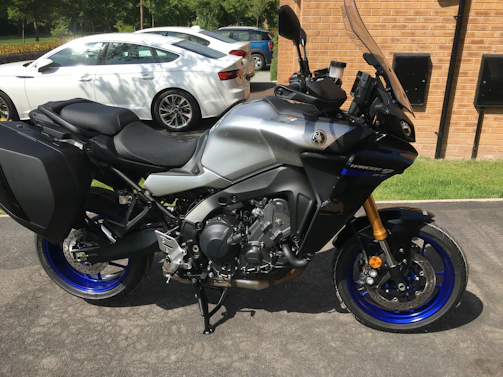 A sleek Yamaha motorcycle parked in front of a modern dealership building with blue and black accents.