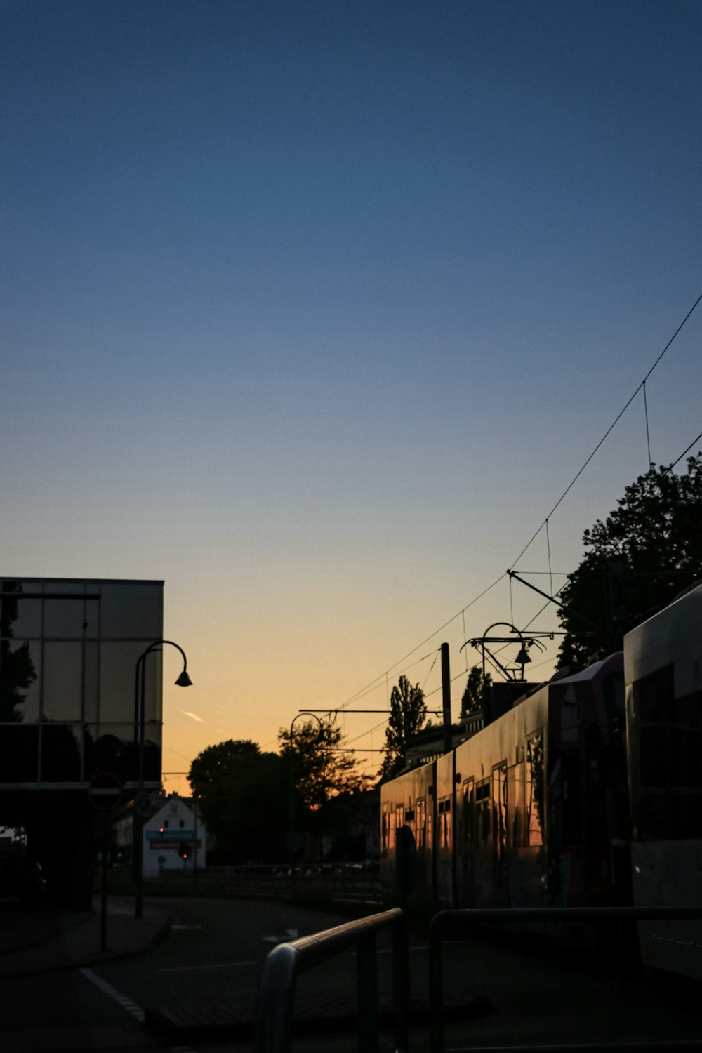 the sun is setting behind a train on the tracks