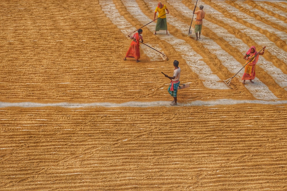 a group of people standing on top of a dry grass field