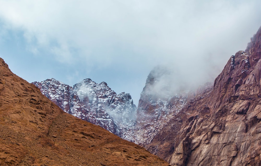 a mountain range covered in snow and clouds