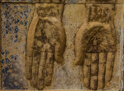 a pair of hands carved into the side of a building