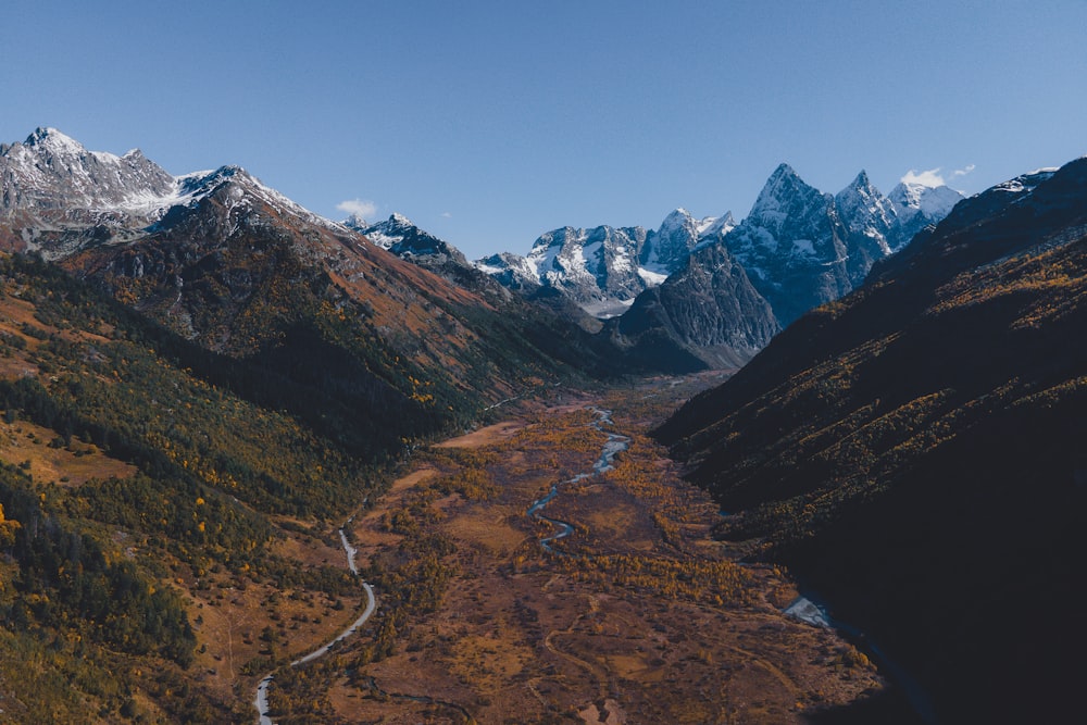 a valley surrounded by mountains with a river running through it