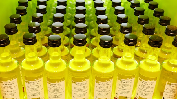 A bottle of limonceili surrounded by fresh organic lemons.