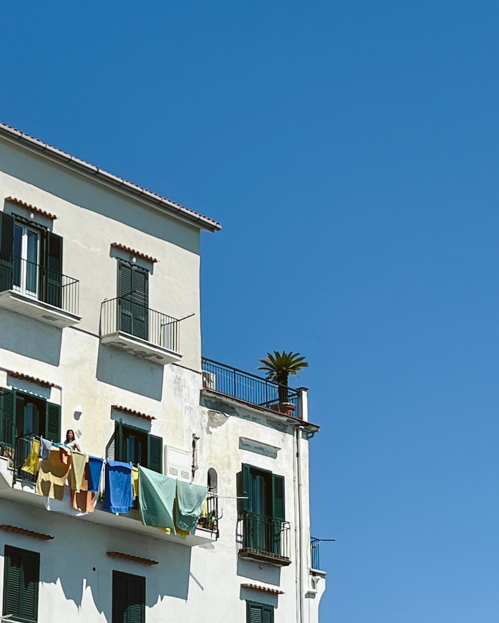 a tall white building with clothes hanging out of the windows