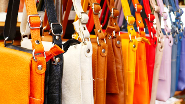 Rows of finished leather bags lined up in a bright, organized workshop.