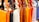 A row of colorful leather handbags displayed in a variety of vibrant shades ranging from orange, black, white, and brown to yellow, red, purple, and pink. The bags are neatly hung by their straps, highlighting their design and metallic buckles.