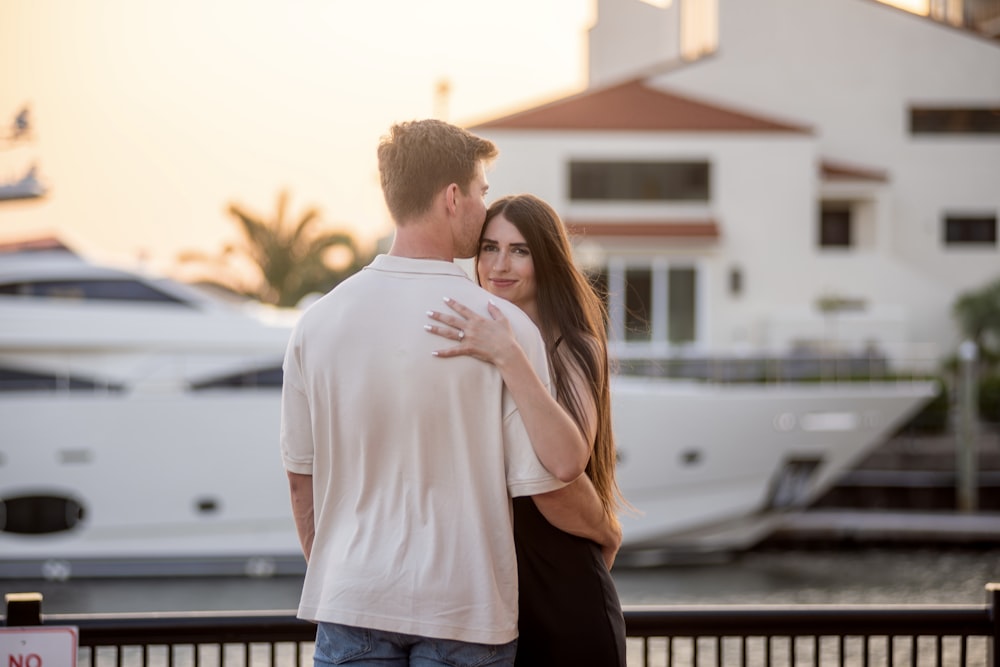 a man and a woman embracing in front of a boat