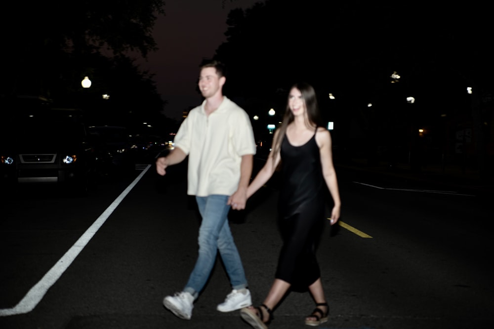 a man and a woman walking down a street at night