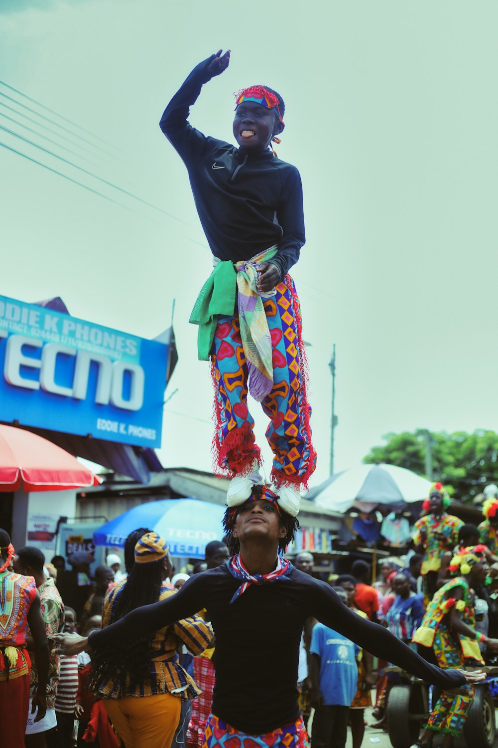 a man standing on top of another man on a street