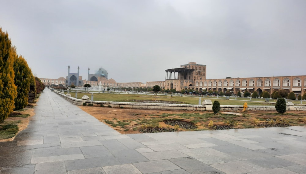 a large building sitting next to a lush green field