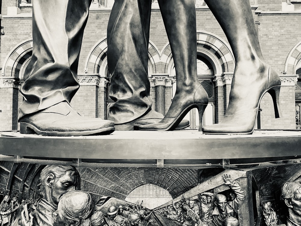 Ein Schwarz-Weiß-Foto einer Statue mit einem Paar Beinen