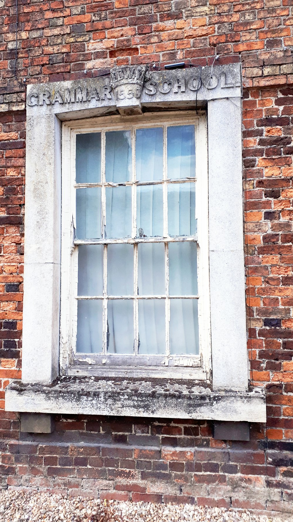 a brick building with a window and a sign on it