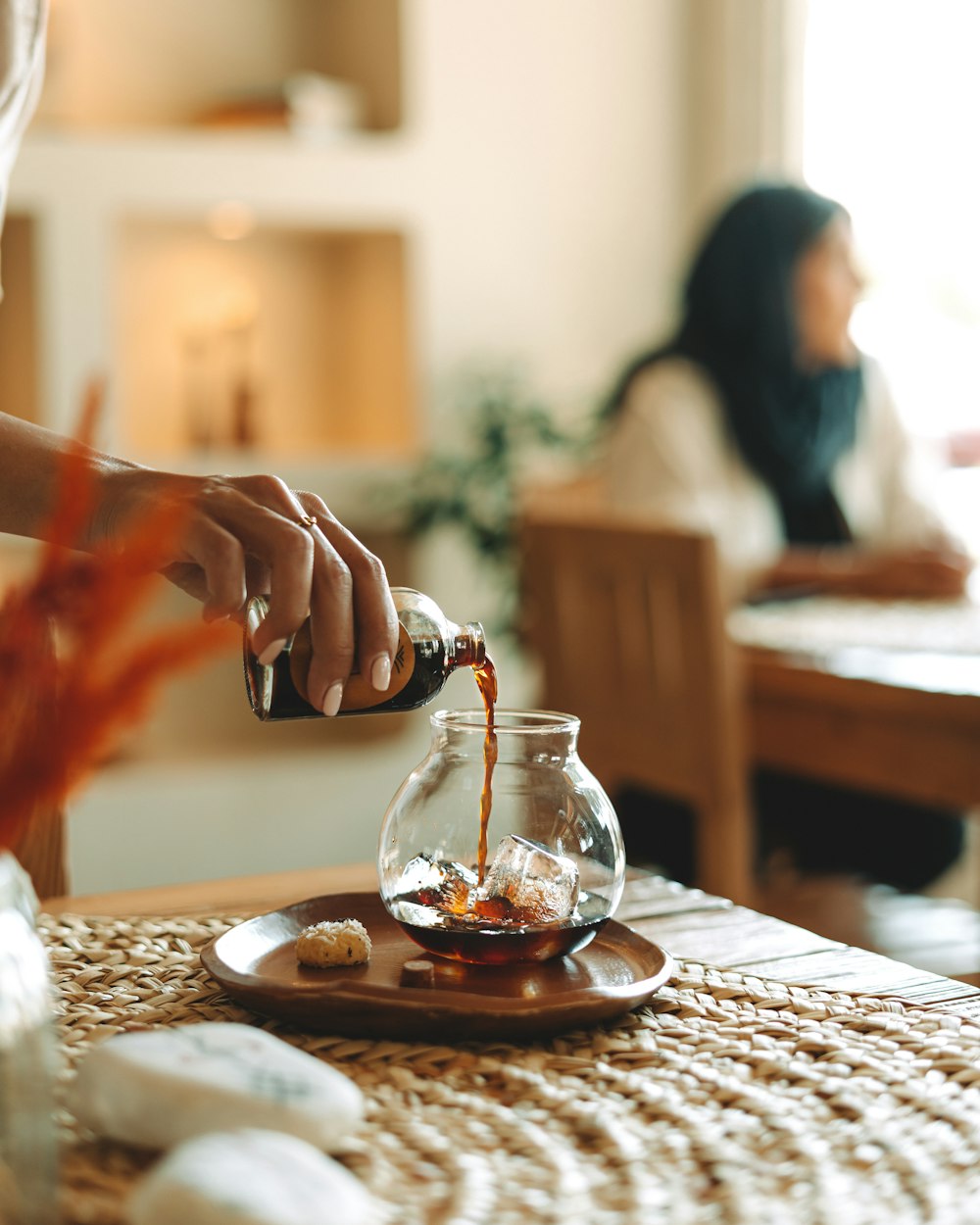 a woman pours coffee into a fish bowl