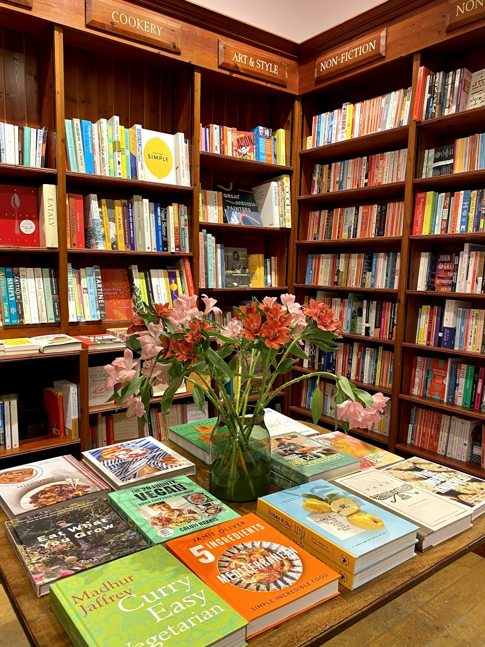 a vase of flowers on a table in a library