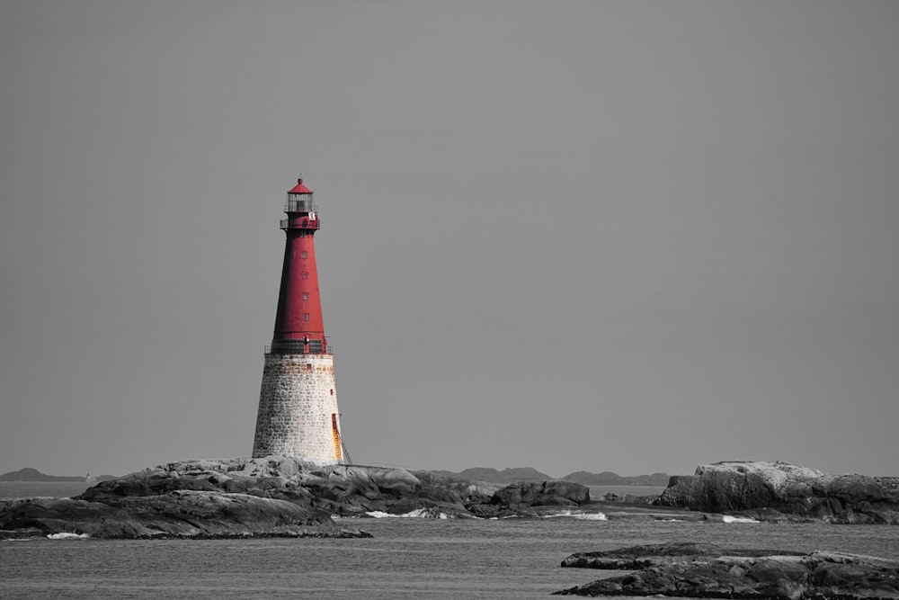 a black and white photo of a red and white lighthouse