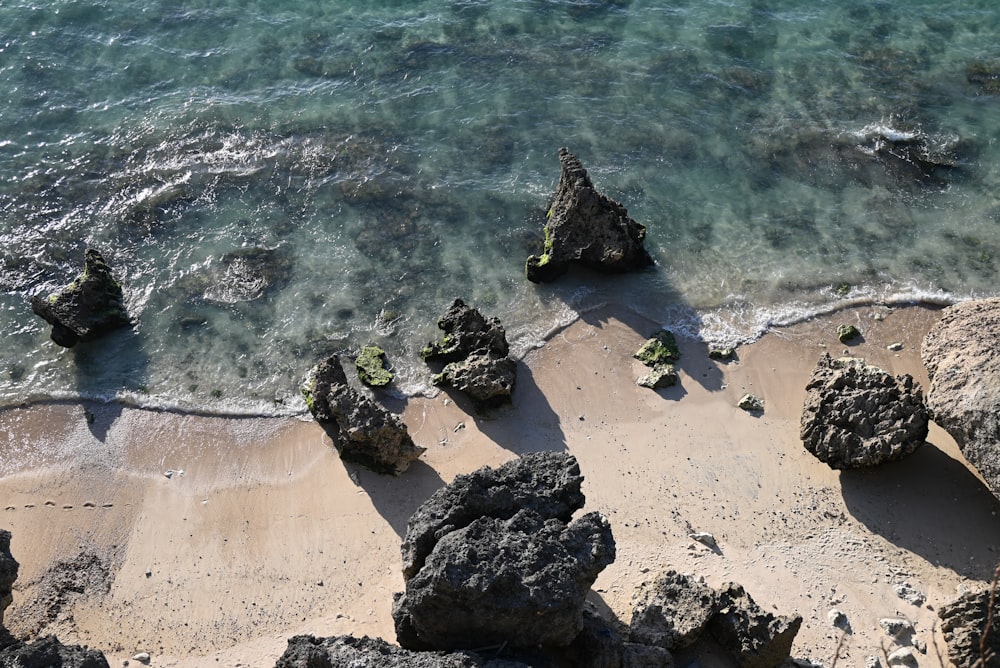 an aerial view of a beach with rocks and water