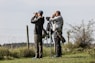 a couple of men standing on top of a lush green field