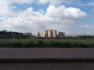a large building sitting on top of a lush green field