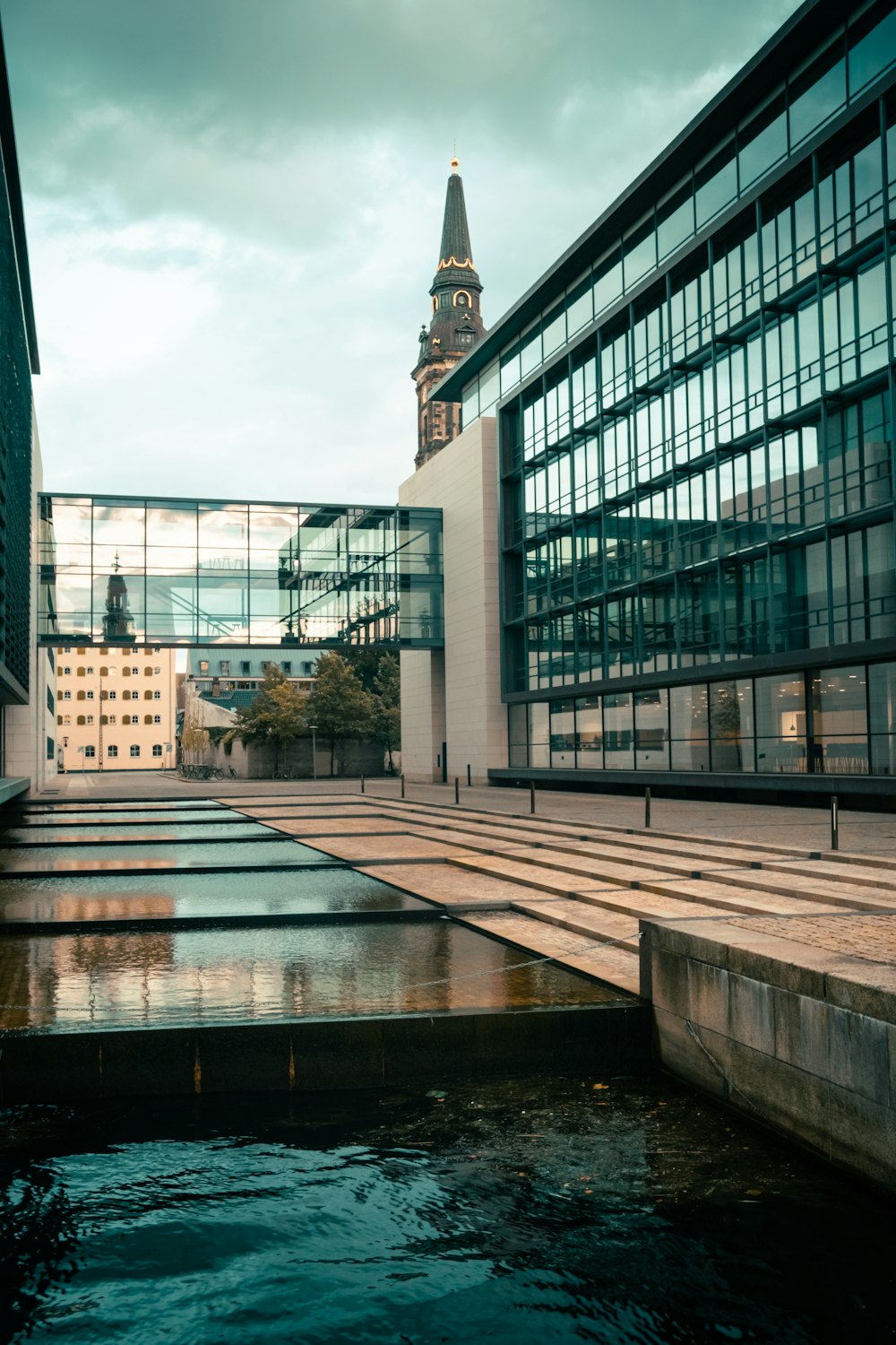 a building with a clock tower next to a body of water