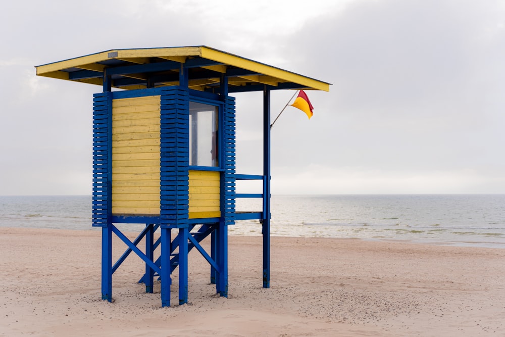 a yellow and blue lifeguard tower on a beach