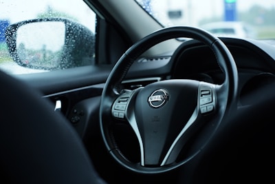 A set of custom-fit car floor mats laid out inside a Nissan vehicle.