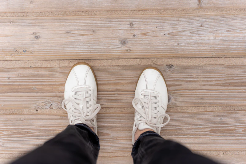 Looking down at a pair of clean white trainers
