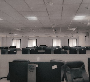 a room filled with lots of empty computers and chairs