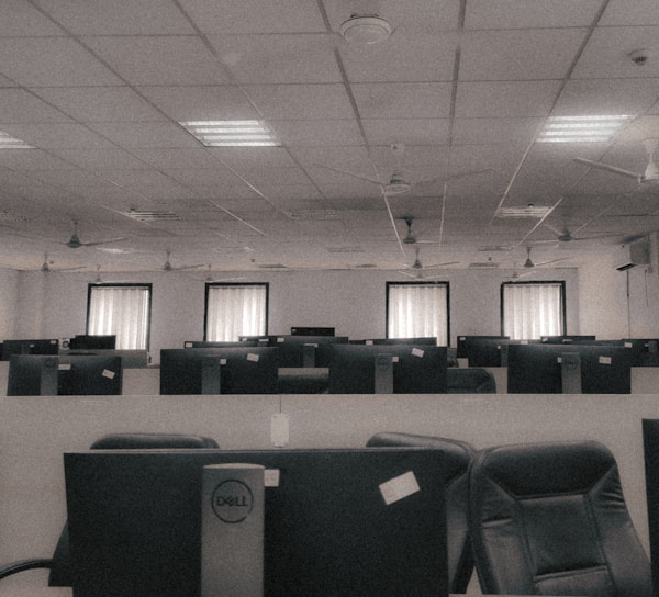 a room filled with lots of empty computers and chairs