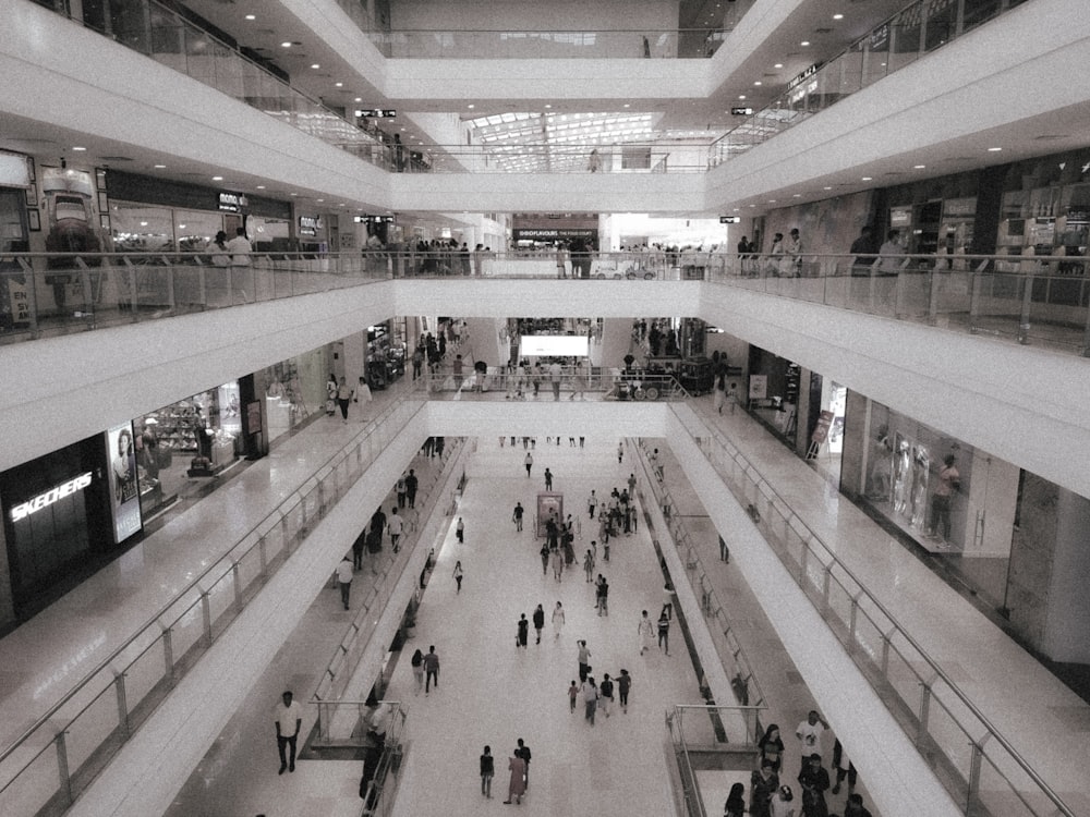 a black and white photo of people in a shopping mall